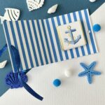 Interno porta cioccolatino marinaro con cioccolatino ancora e sfondo righe blu